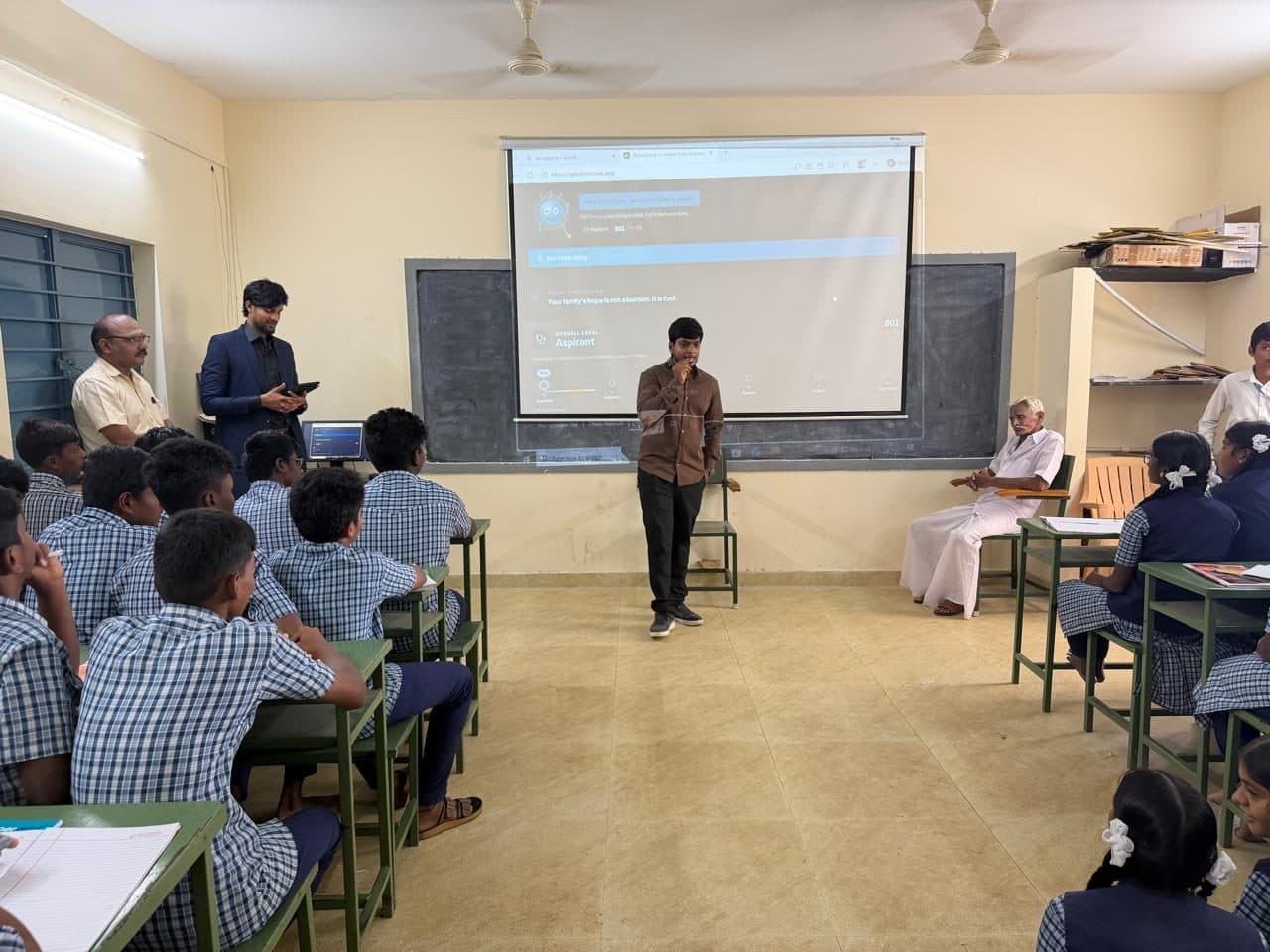The introduction session at Annur: DriveScore open in a browser on the classroom projector, with students, teachers and school elders watching.