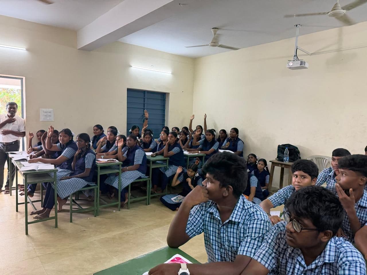 Students in the session with their hands raised to answer a question.
